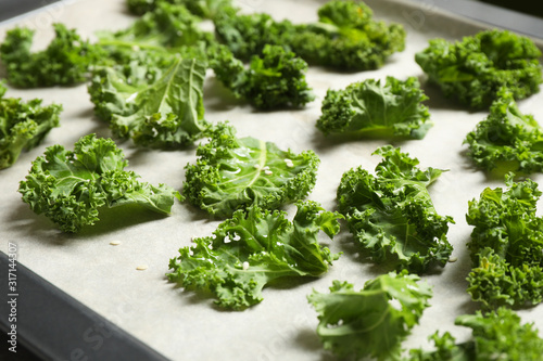 Raw cabbage leaves on baking sheet, closeup. Preparing kale chips