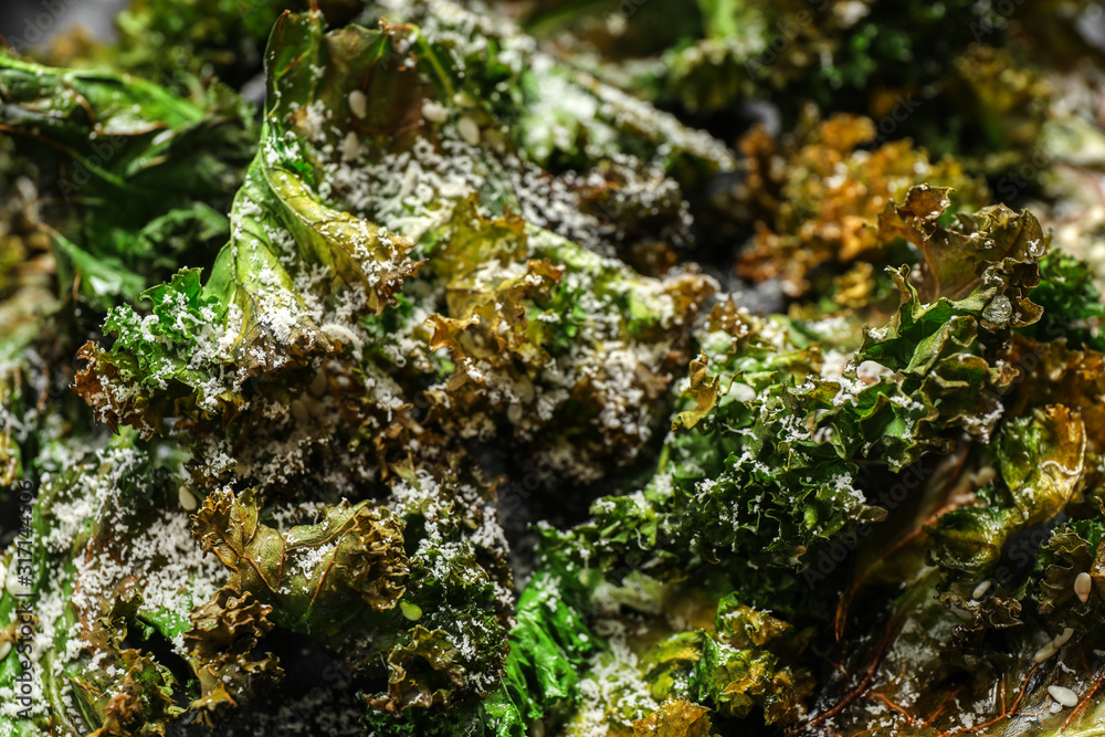 Tasty baked kale chips with grated cheese as background, closeup Tasty baked kale chips with grated cheese as background, closeup