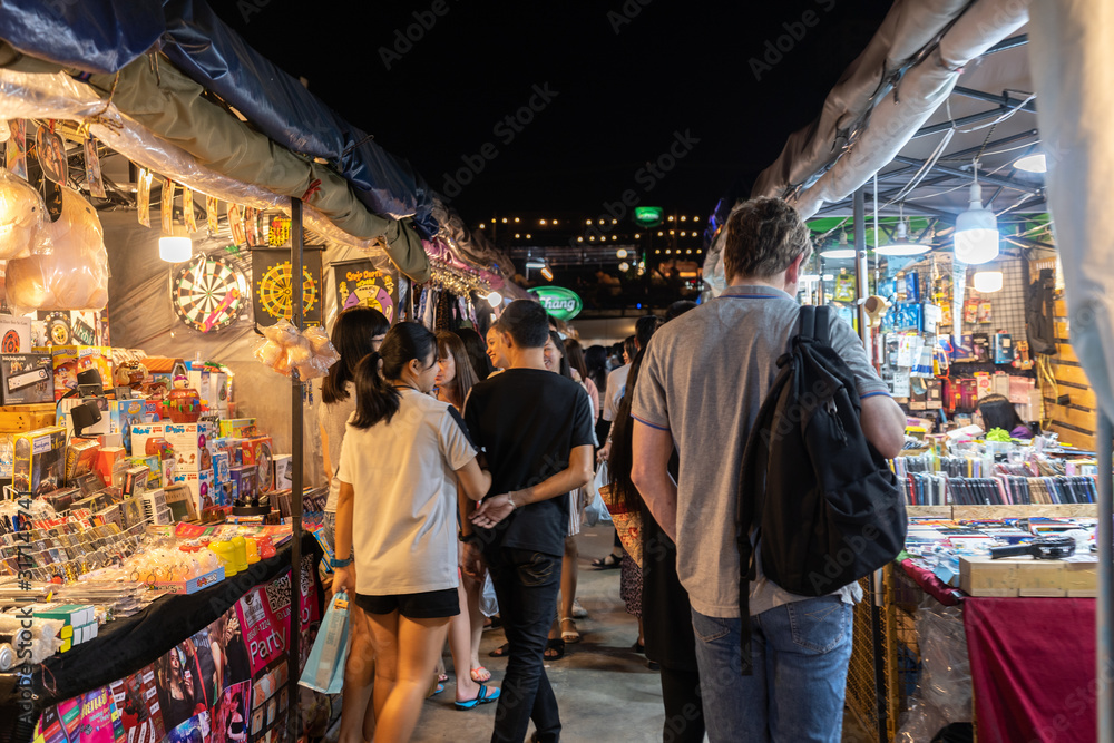 Tourist and locals walking and shopping at Rachada Night train market (Talad Rot Fai). market with plenty of shops with colorful canvas roofs at night in Bangkok, Thailand