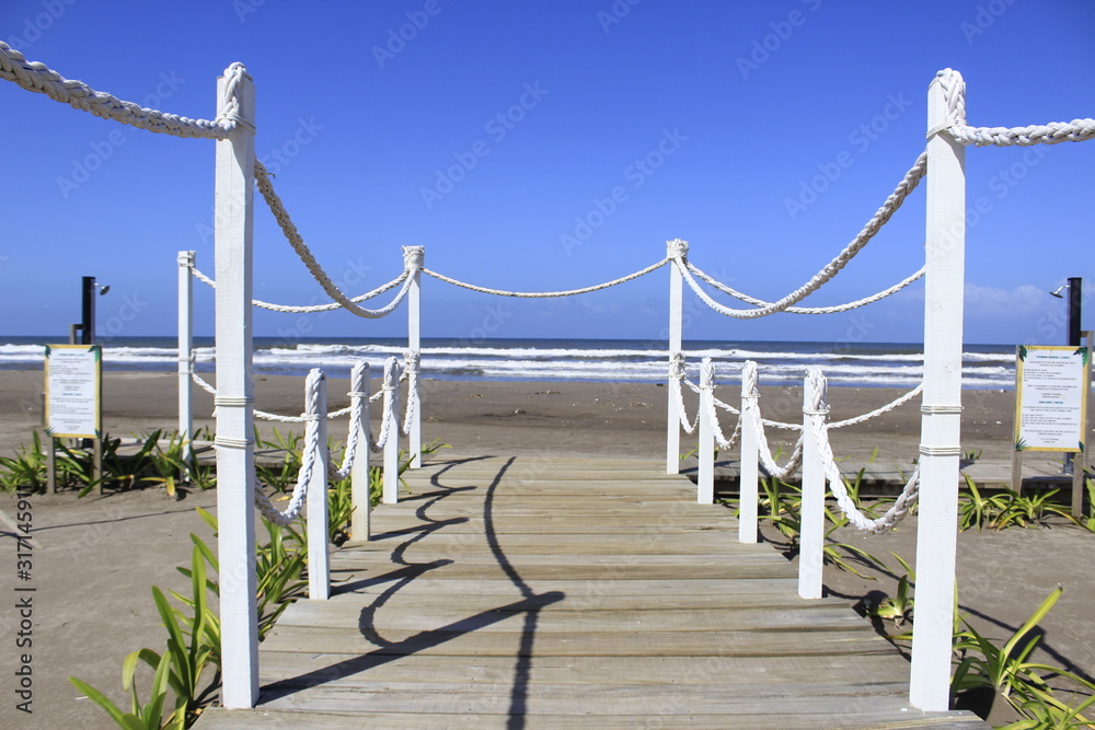 Naklejka premium wooden path to the beach shore