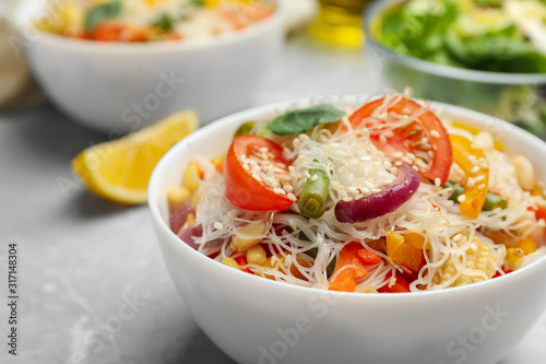 Tasty cooked rice noodles with vegetables on table, closeup