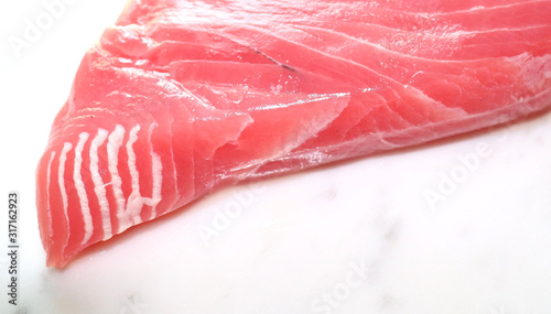 View of red fresh tuna steak in the Kitchen on a white marble background