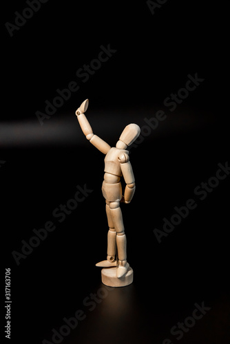 a happy wooden figure of a man takes a selfie and admires himself as if he has narcissism