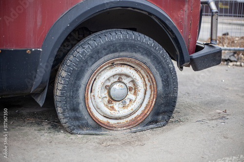 Transport repair. Spiked wheel of a car. Replacing the wheel of a car. Old transport has fallen into disrepair.