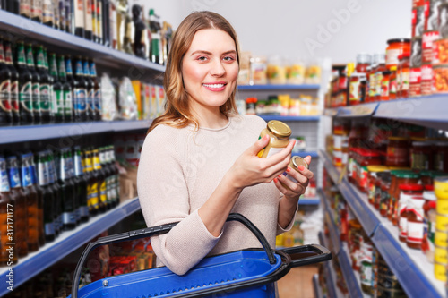 Female choosing preserves in grocery