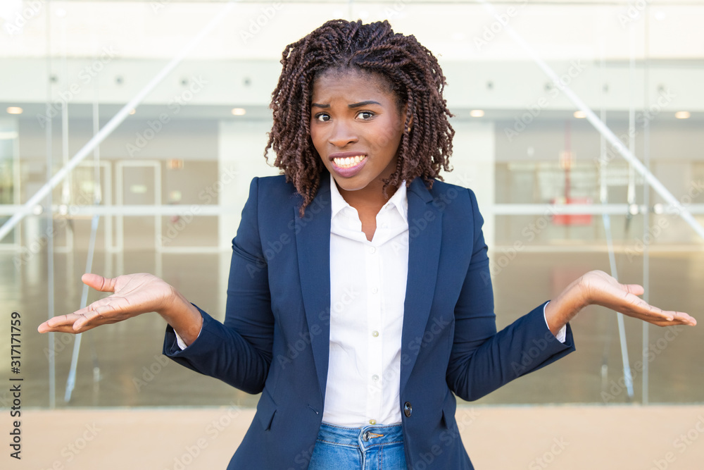 Φωτογραφία Doubtful young businesswoman looking at camera