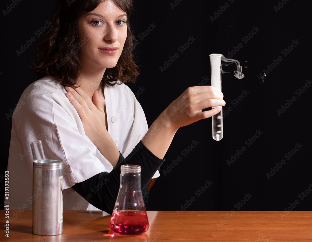 Φωτογραφία Close-up of a woman holding a cylinder with chemical reaction fumes