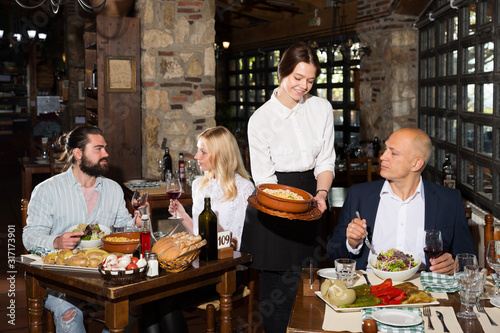 Female owner of rustic restaurant serving guests