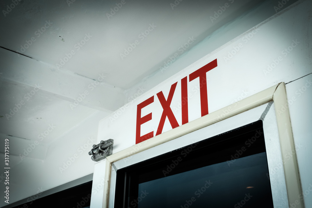 A close-up red exit directional sign with white background A close-up red exit directional sign with white background