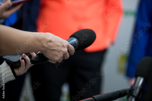 Hand with microphone doing an interview for the media, selective focus