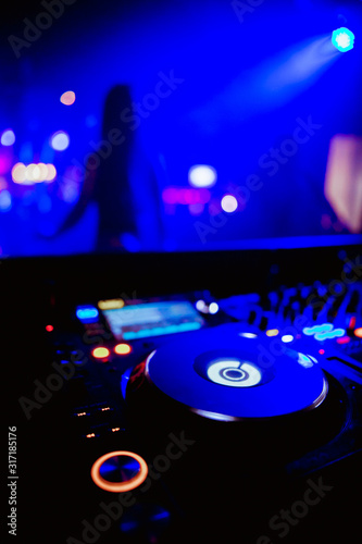 DJ Spinning, Mixing, and Scratching in a Night Club, Hands of dj tweak various track controls on dj