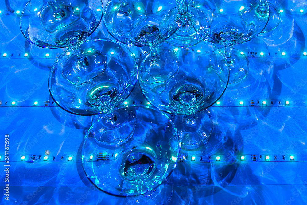 A pile of champagne glasses at a party. Alcoholic luxury pyramid of wineglass.