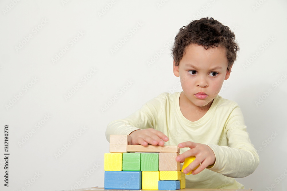 boy with toy building blocks testing his creativity by building towers learning and been educated at school boy with toy building blocks testing his creativity by building towers learning and been educated at school