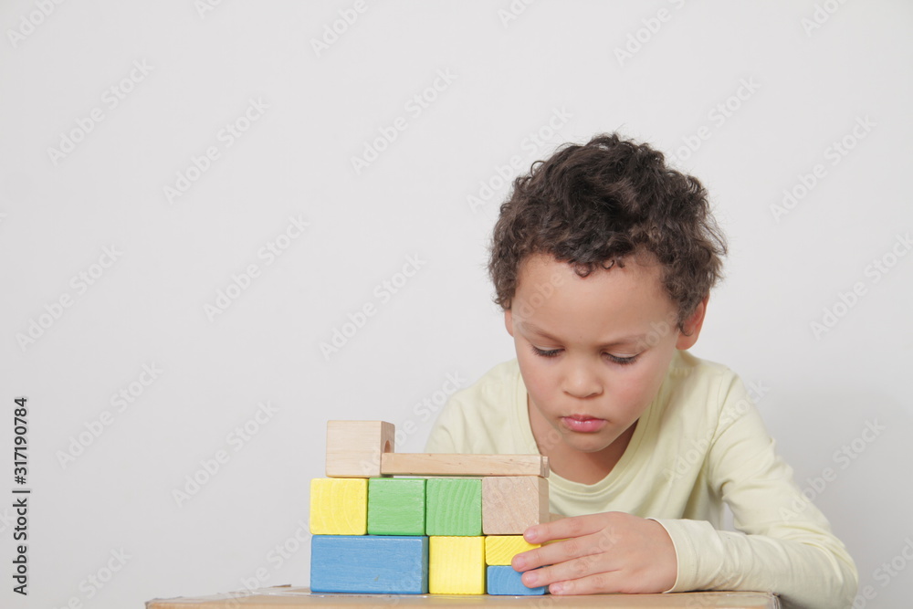 boy with toy building blocks testing his creativity by building towers learning and been educated at school boy with toy building blocks testing his creativity by building towers learning and been educated at school