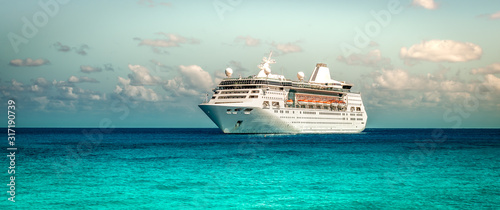 Cruise ship sailing on the Caribbean Sea. Side view of the vessel. Wide image.