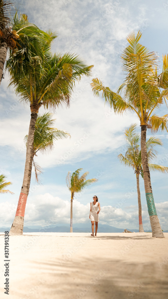 young woman on the beach with palmtrees