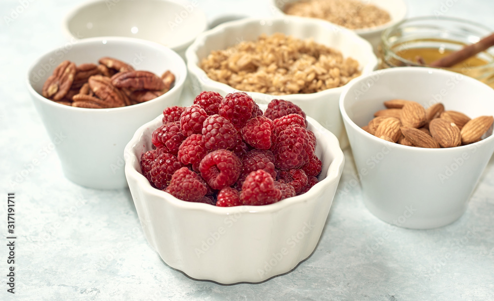 fresh and juicy raspberries in a white bowl on gray background fresh and juicy raspberries in a white bowl on gray background