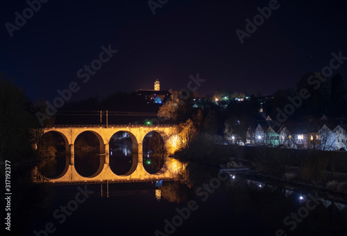 old stone bridge over the river at night in autumn in bavaria