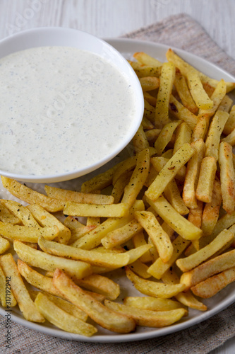 Homemade Crispy Ranch Fries on a gray plate on a white wooden surface  low angle view. Close-up.