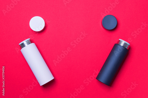 black and pink thermos cup on red colored paper background