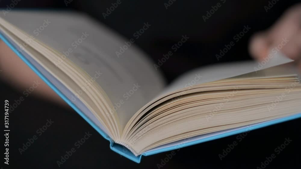 Hand and book: reading a book and holding your fingers along the lines. A woman's hand holds a book and moves her fingers along the page while reading. The reader of the book holds