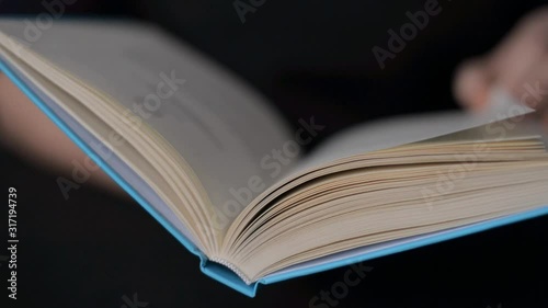 Hand and book: reading a book and holding your fingers along the lines. A woman's hand holds a book and moves her fingers along the page while reading. The reader of the book holds photo