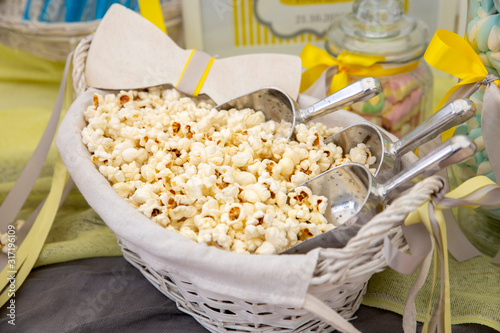 A closeup of a basket full of popcorns on the table under the lights