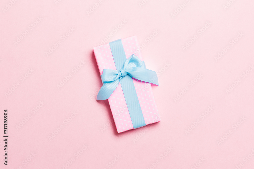 Top view Christmas present box with blue bow on pink background with copy space Top view Christmas present box with blue bow on pink background with copy space