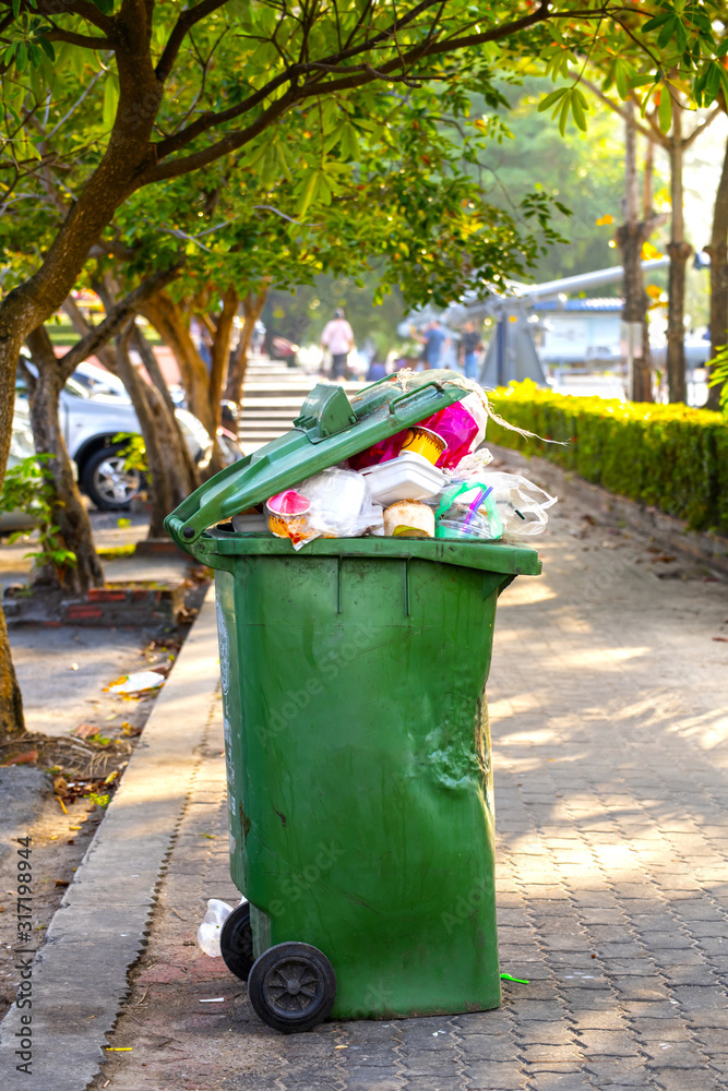 Green waste bins in the park with garbage-tight waste and defective conditions Green waste bins in the park with garbage-tight waste and defective conditions