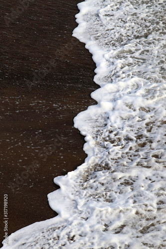 Waves washing up sandy beach coastline