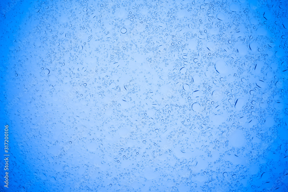 Rain droplets on blue glass background, Water drops on blue glass.