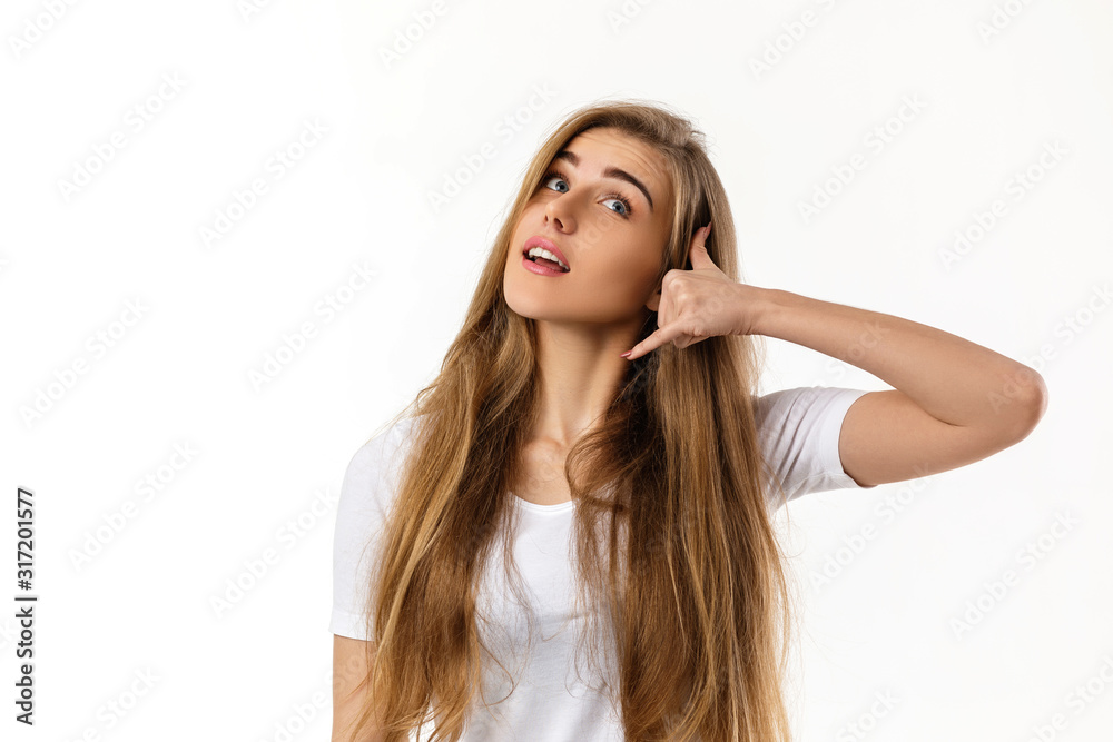 smiling young woman showing phone gesture on white background. girl makes call me back with hand smiling young woman showing phone gesture on white background. girl makes call me back with hand