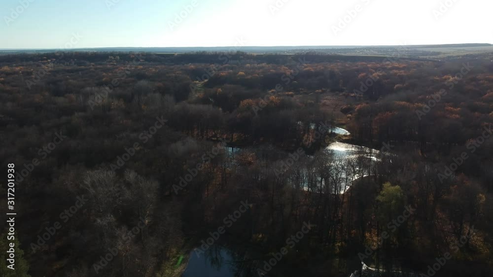 Flight over the forest river. Autumn. Blue water in the river. The sun. Flight over the forest river. Autumn. Blue water in the river. The sun.