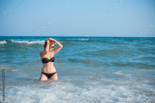 Plus size nice young woman with full hips and pretty figure in fashionable swimsuit rest at sea, vacation and trip concept