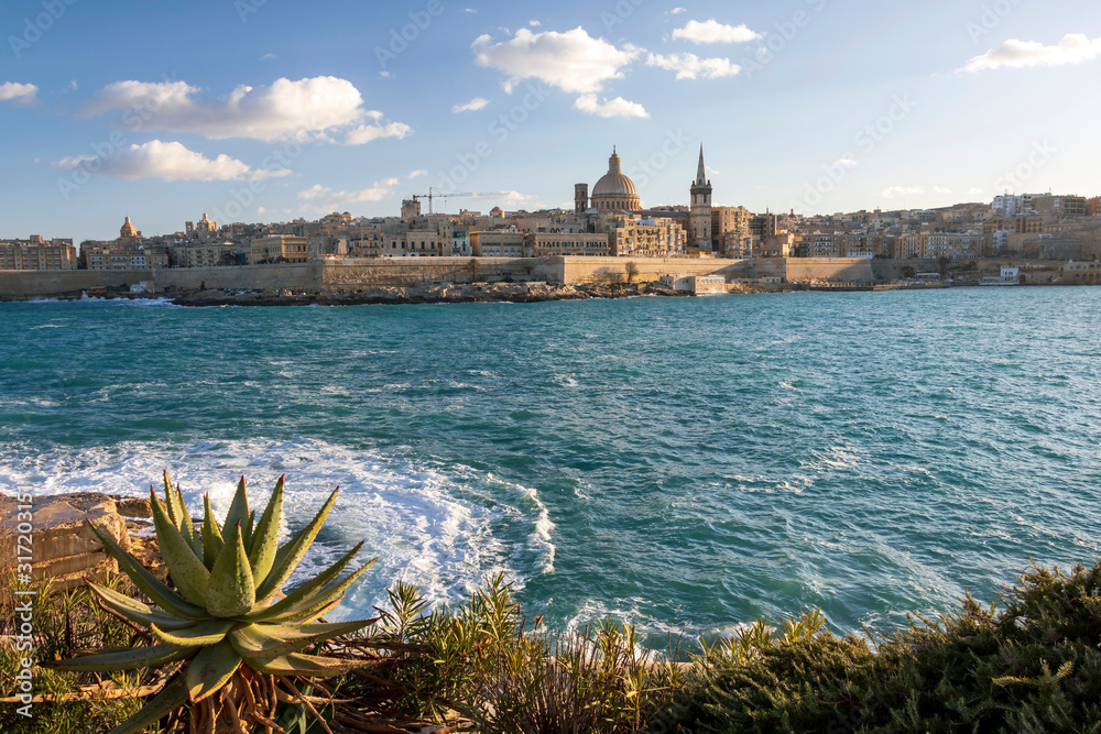 Panoramic view of Valletta, seafront skyline of the capital city of Malta from Sliema shoreline with green flora