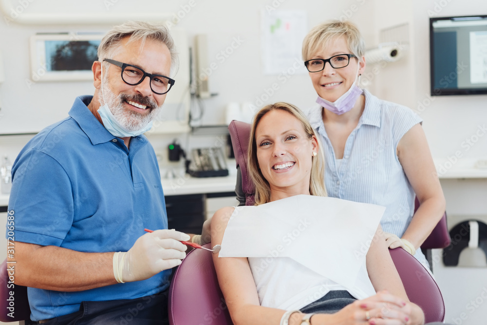 Smiling female patient posing with her dentist Smiling female patient posing with her dentist