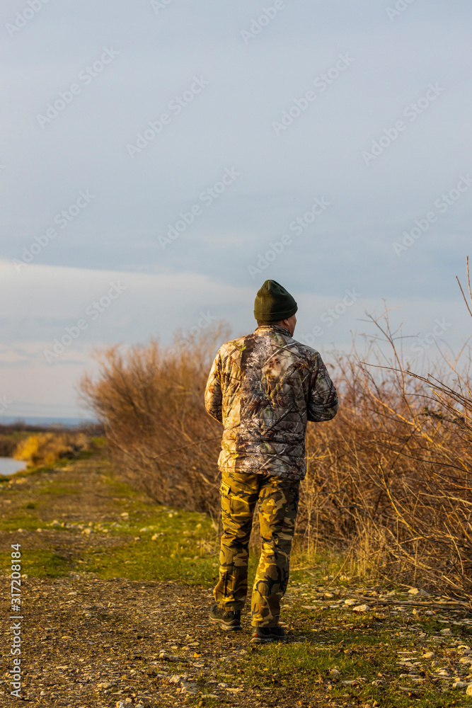Professional wildlife photographer in camouflage clothing Professional wildlife photographer in camouflage clothing