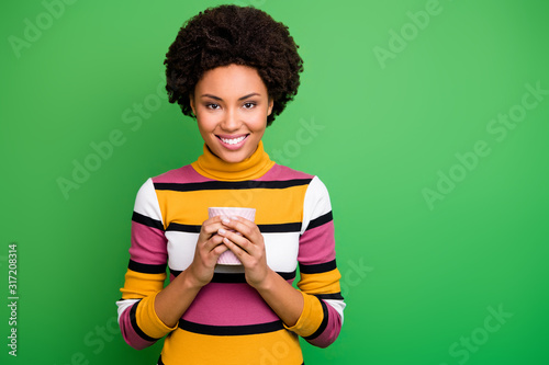 Portrait of cheerful calm afro american girl hold hot caffeine beverage cup enjoy fall weekends wear good look clothes isolated over green color background