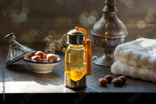 Bottle of Argan oil on a table with fruits