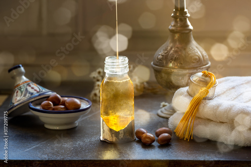 Bottle of Argan oil on a table with fruits