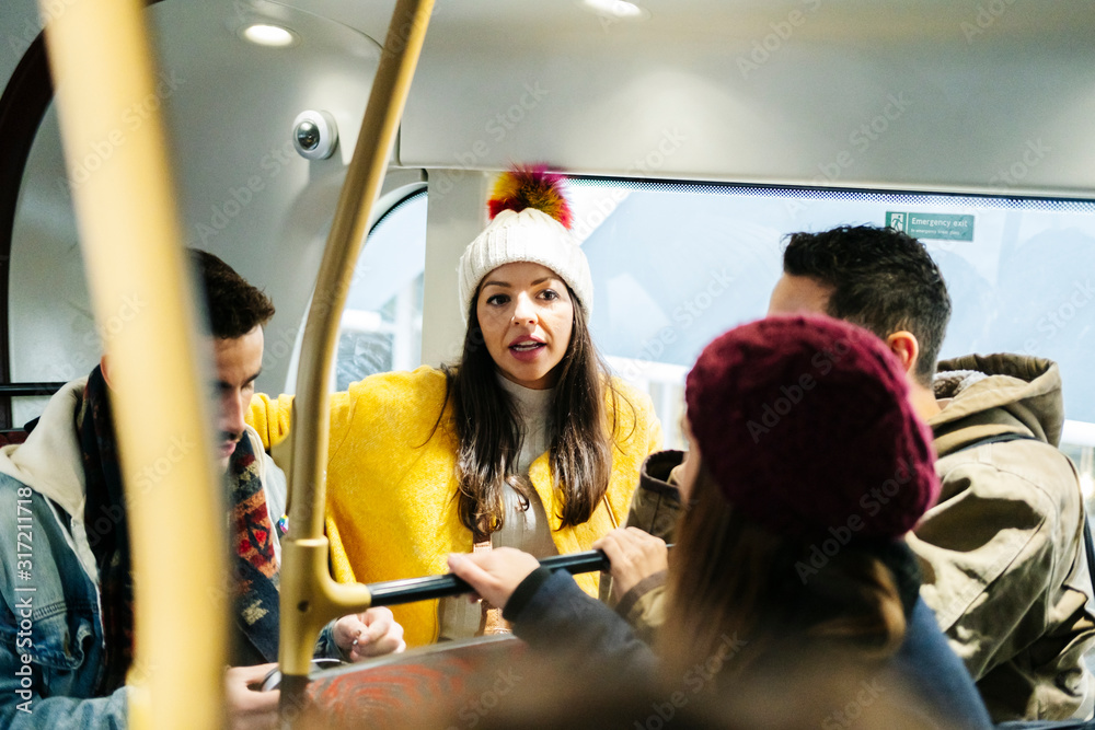A group of friends talking travel in an urban bus A group of friends talking travel in an urban bus