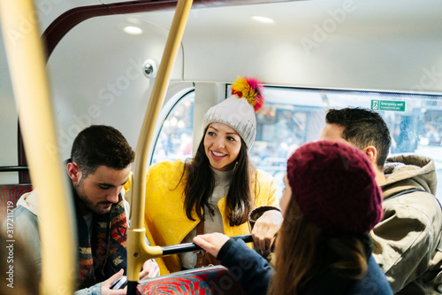 A group of friends talking travel in an urban bus