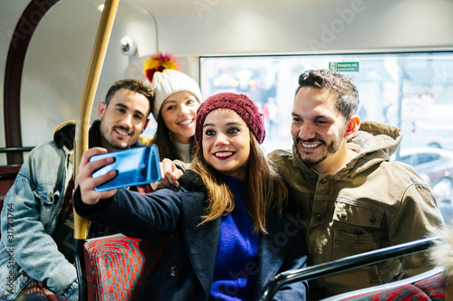 A group of friends take a selfie on an urban bus