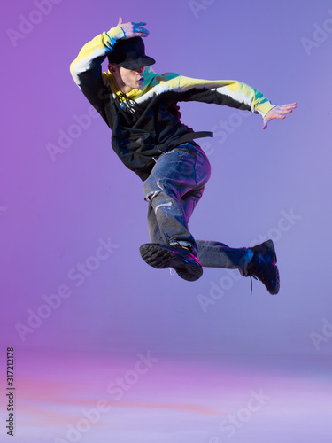 Fototapeta Naklejka Na Ścianę i Meble -  Breakdancing young man in hoodie and baseball cap. Dance school poster. Copy space. Battle competition announcement.