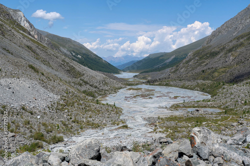 Mountainous landscape. View at beautiful alpine valley with a river.