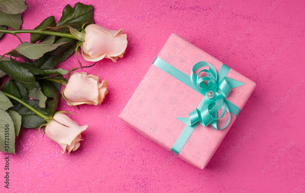 A gift for the holiday in the form of flowers and boxes in pink paper on a pink background. A gift for the holiday in the form of flowers and boxes in pink paper on a pink background.