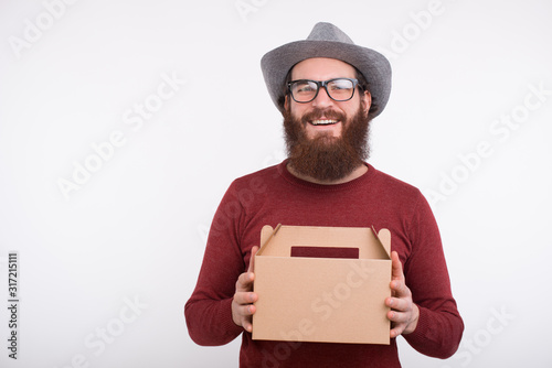 Cheerful bearded man is smiling at the camera holding a lunch box. It's time to eat.