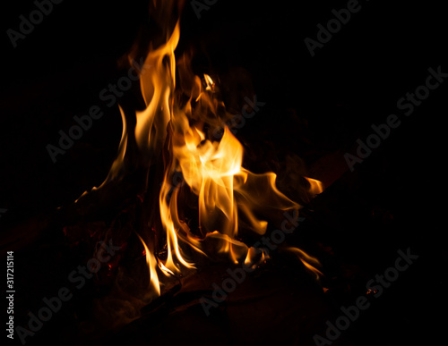 Fire flame caused by burning of wood on a black background