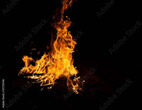 Fire flame caused by burning of wood on a black background