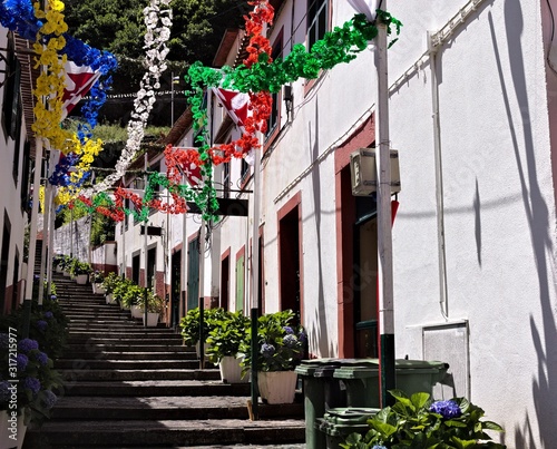 A street with a flight of steps decorated with colored paper flowers for a traditional festival in Sao Vicente (Madeira, Portugal, Europe)